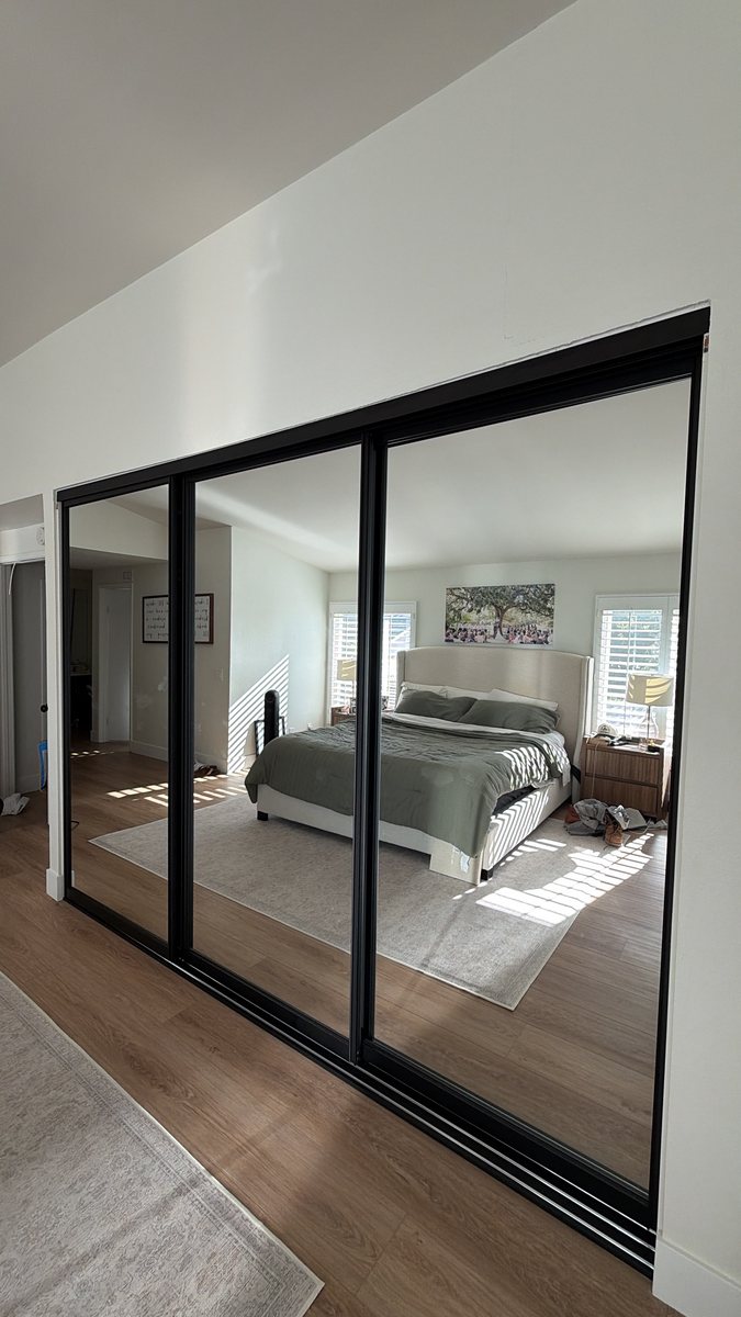 Black frame mirror sliding closet doors in an Orange County master bedroom