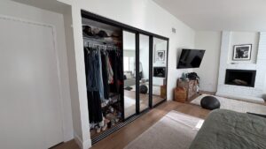 Black-frame mirrored closet doors installed in an Orange County bedroom