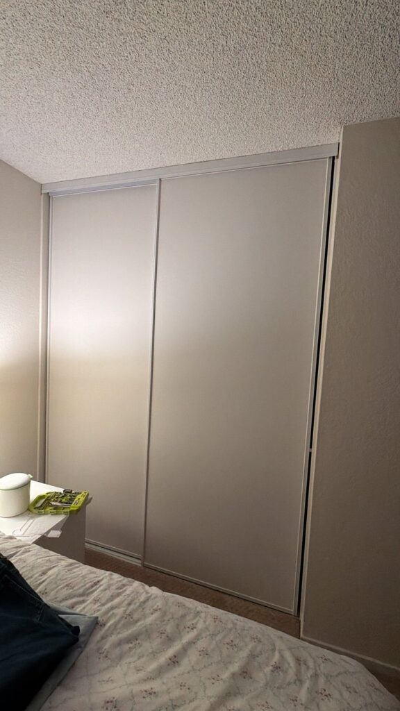 Flat painted bypass closet doors in a bedroom