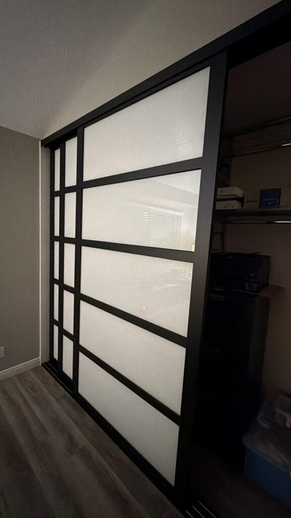 Black-frame frosted glass sliding closet doors installed by The Door Replacement Company, serving Newport Beach, CA