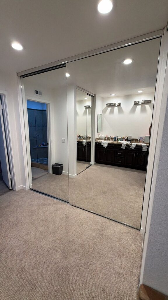 Full-height mirrored sliding closet doors with silver aluminum frames