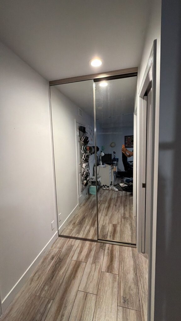 Tall mirrored sliding closet doors reaching close to the ceiling